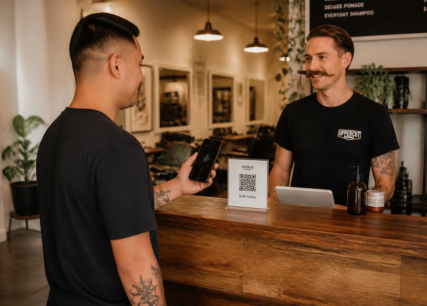 Customer scanning a QR code at a barbershop counter